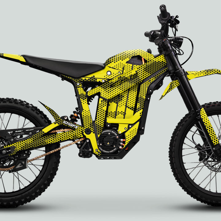 Side-view of an electric dirt bike featuring Talaria Sting MX5 PRO Graphics Kit with HEXOCAM yellow decals on hexagon-patterned frame, enhancing style and durability.