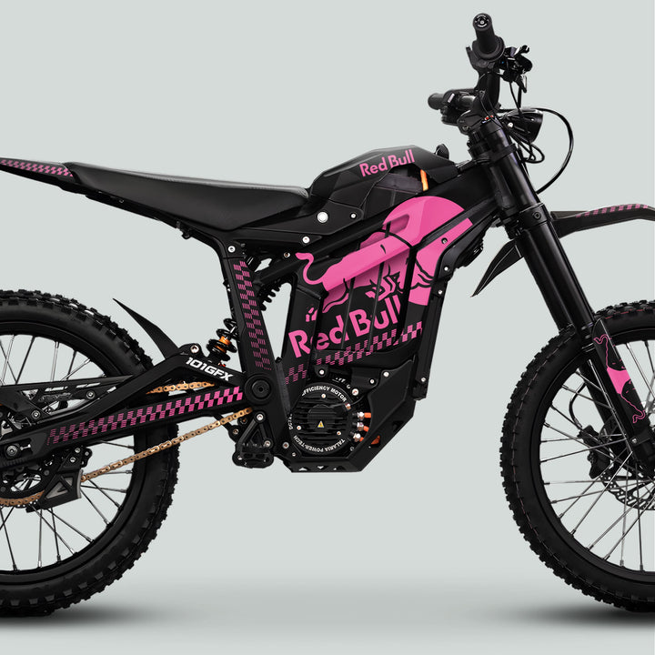 Side-profile of Talaria Sting MX5 PRO Graphics Kit, featuring black frame with hot-pink Red Bull logos, heavy-tread tires, and sleek electric dirt-bike design.