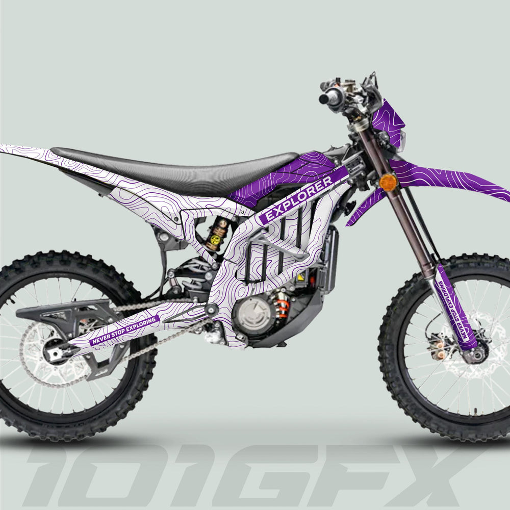 Surron Ultra Bee Graphics Kit EXPLORER WHITE PURPLE on electric enduro bike, featuring topographic map pattern, knobby tires, visible motor, and disc brakes.