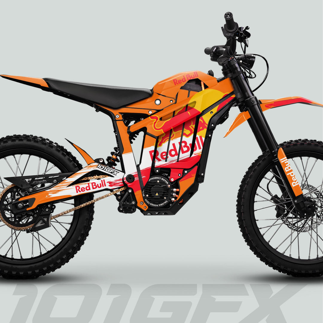 Side-view of Talaria Sting MX5 PRO Graphics Kit RBULL RACE Orange Decals on off-road e-bike, showcasing knobby tires, suspension, battery, and Red Bull branding.