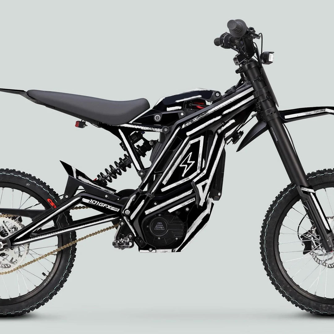 Side-view of a black e-dirt bike featuring the E Ride Pro SS Graphics Kit BRUSH Black White, showcasing knobby tires, rear suspension, and electric motor/battery assembly.