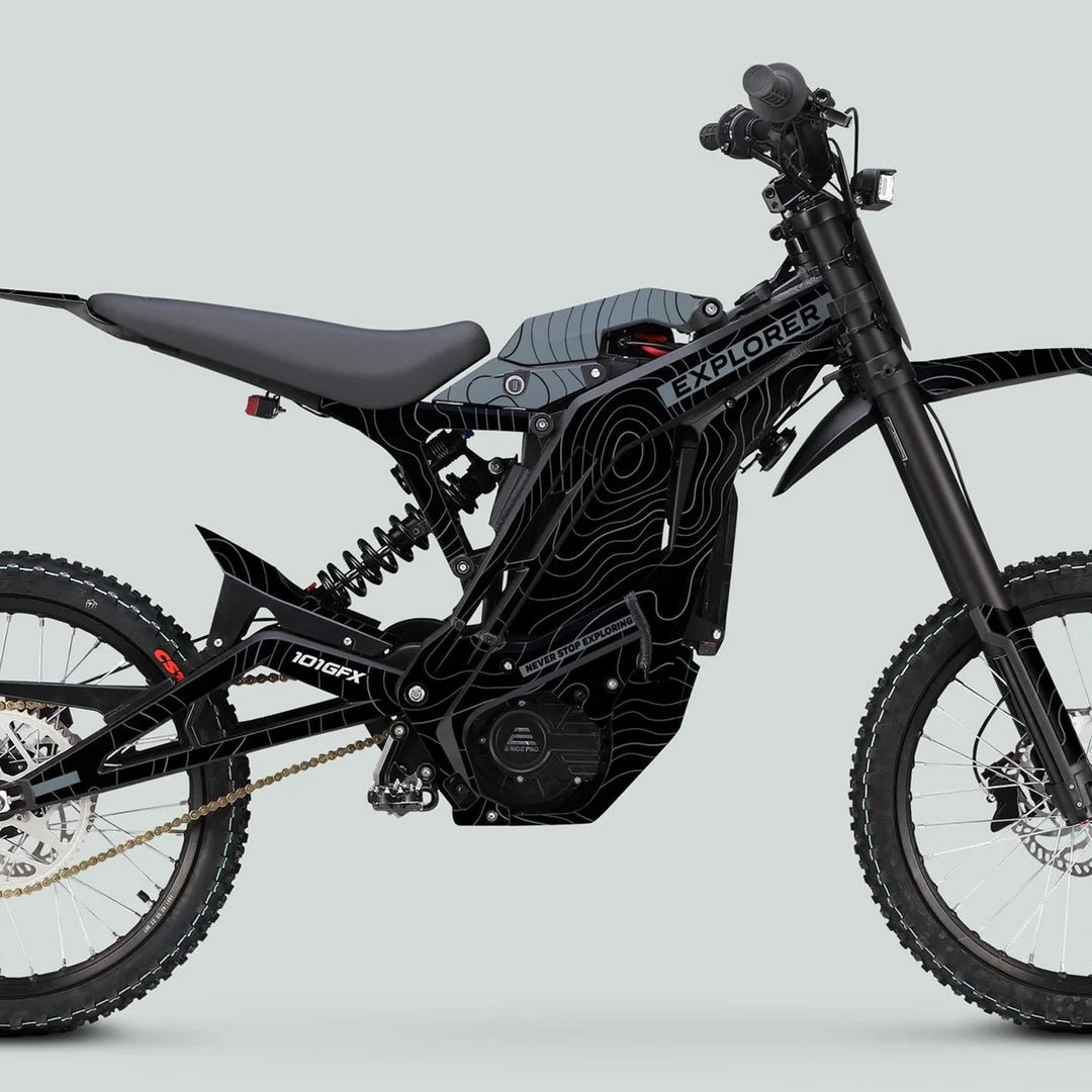 Side view of an off-road e-bike featuring the E Ride Pro SS Graphics Kit EXPLORER Black Grey with knobby tires, suspension, and mid-frame battery.