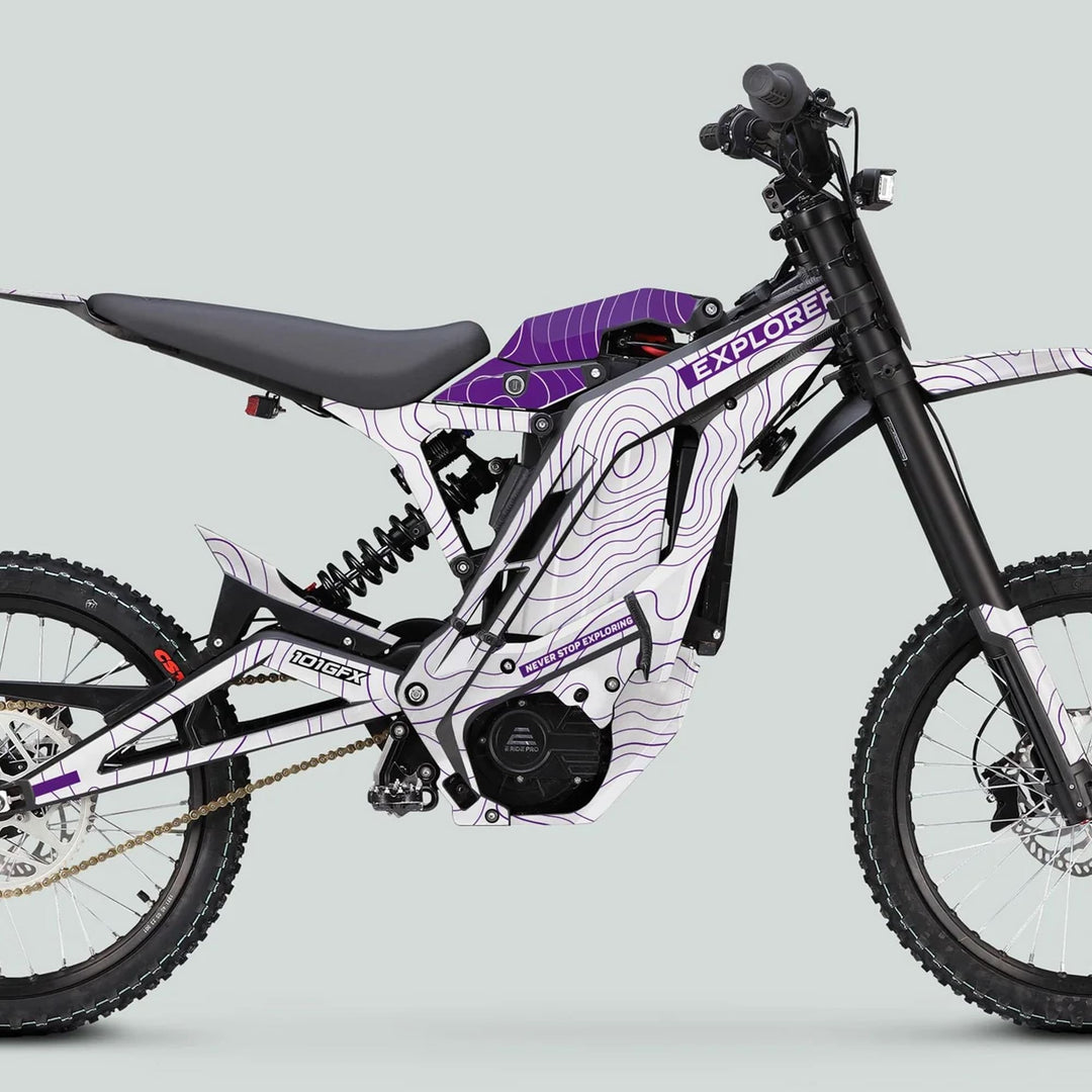 E Ride Pro SS Graphics Kit EXPLORER White Purple on an electric off-road bike, showcasing white and purple graphics with NEVER STOP EXPLORING slogan, enhancing style and durability.