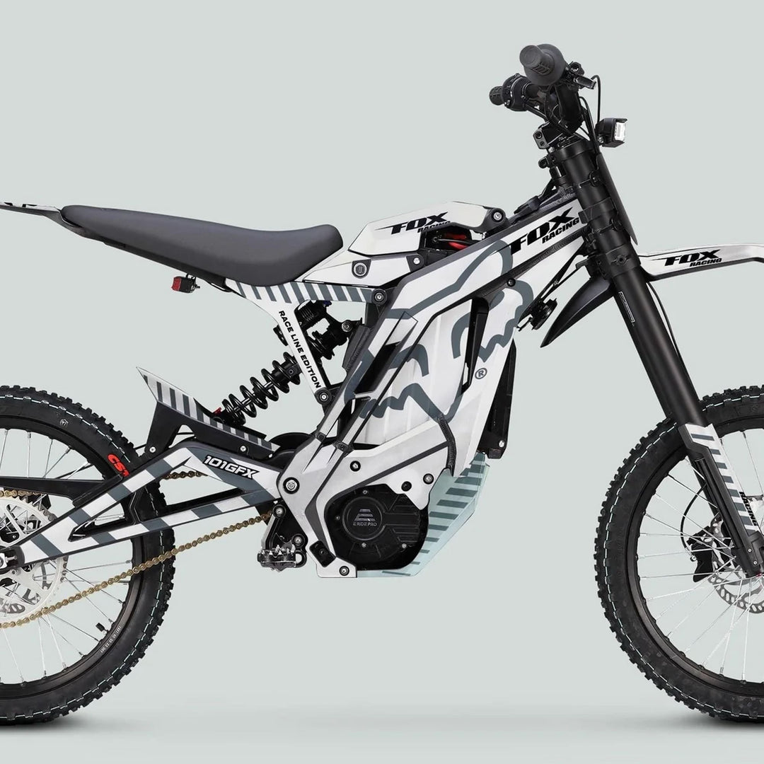 Side-view of an off-road electric motorcycle with E Ride Pro SS Graphics Kit, featuring FOX Race Line motifs, enhancing style and performance.