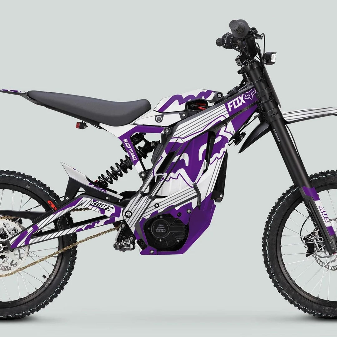 E Ride Pro SS Graphics Kit FOX R Stripes on an e-dirt bike, showcasing a purple, white, and black design with FOX branding, off-road tires, and motor.