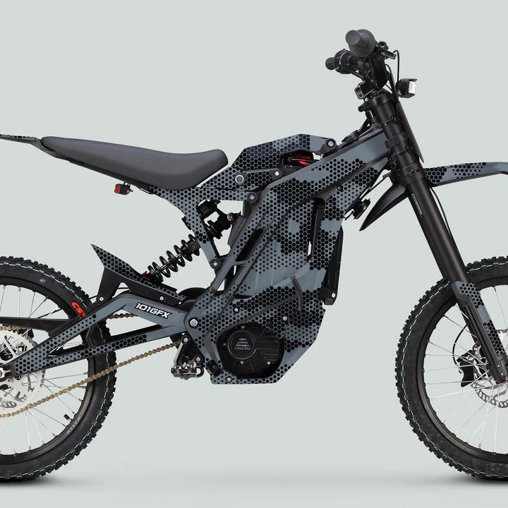 E Ride Pro SS Graphics Kit HEXOCAM GREY on electric off-road motorcycle with knobby tires, spoked rims, gold chain, and “101GFX” motor/battery housing.