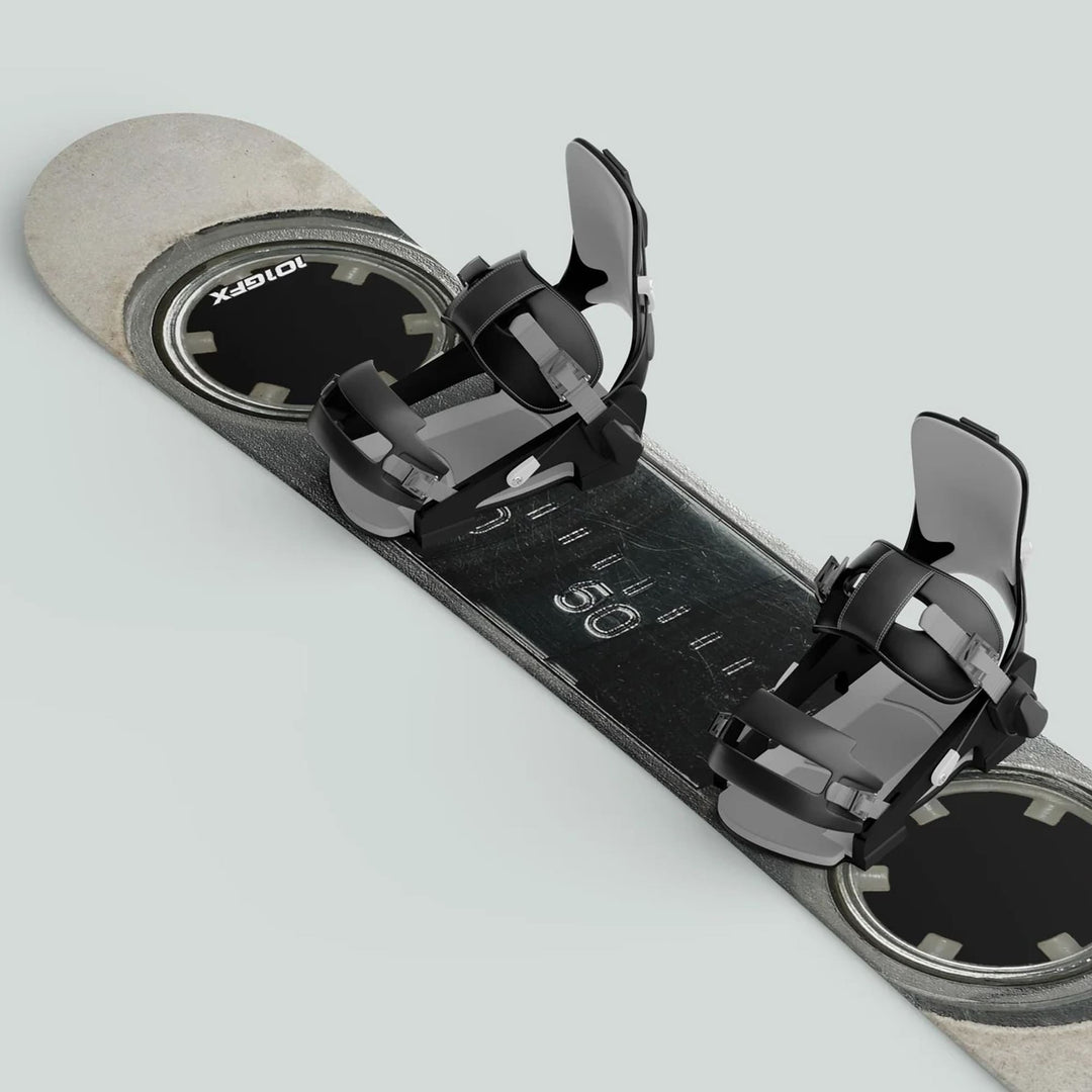 Snowboard outfitted with black-and-gray bindings, featuring the Snowboard Wrap MC Cassette skin decals. Durable, stylish, and protective, ideal for personalizing and safeguarding your gear.