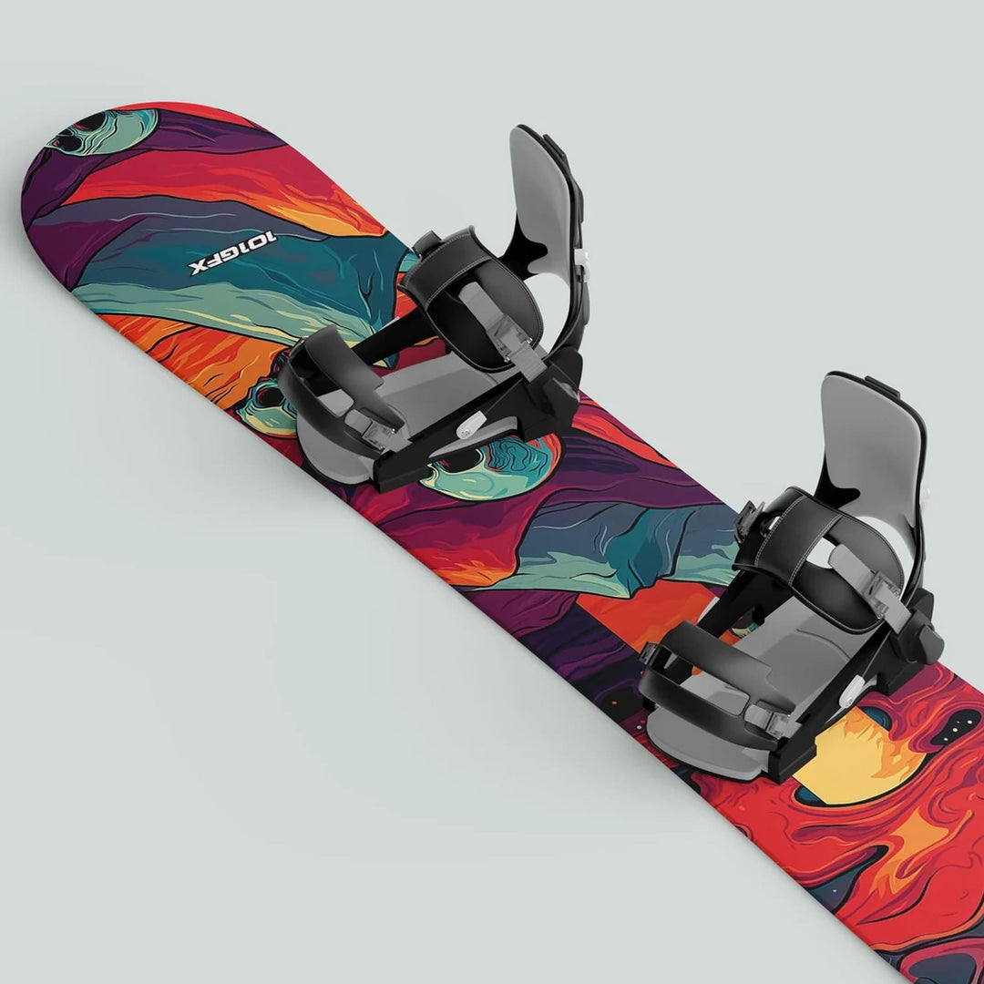 Snowboard with abstract pattern and black bindings, featuring Snowboard Wrap MOUNTAIN SKULLS decals for style and protection on slopes.