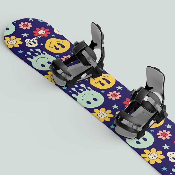 Snowboard with Snowboard Wrap SMILEY sticker skin decals, showcasing vibrant smiling faces, flowers, and stars, complemented by black bindings for a playful, protective design.