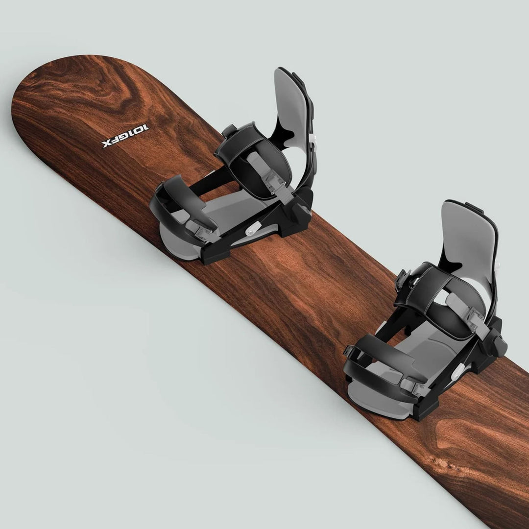 Snowboard Wrap WOOD PLANK sticker skin decals on a snowboard with black-and-gray bindings, enhancing aesthetic and protecting against wear.