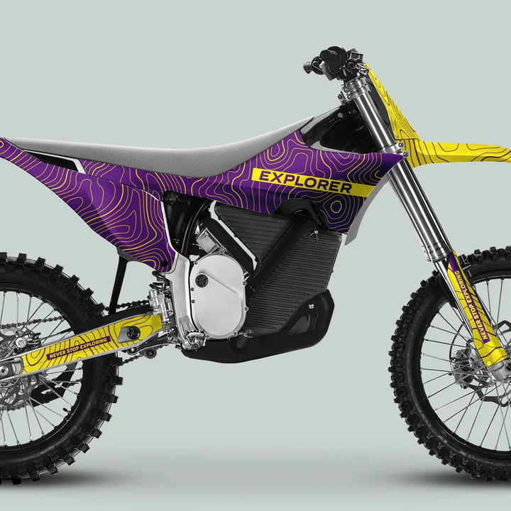 Stark Varg Graphics Kit EXPLORER PURPLE YELLOW on a motocross bike, featuring rugged tires, electric motor, and topographic map pattern for adventurous trail riding.