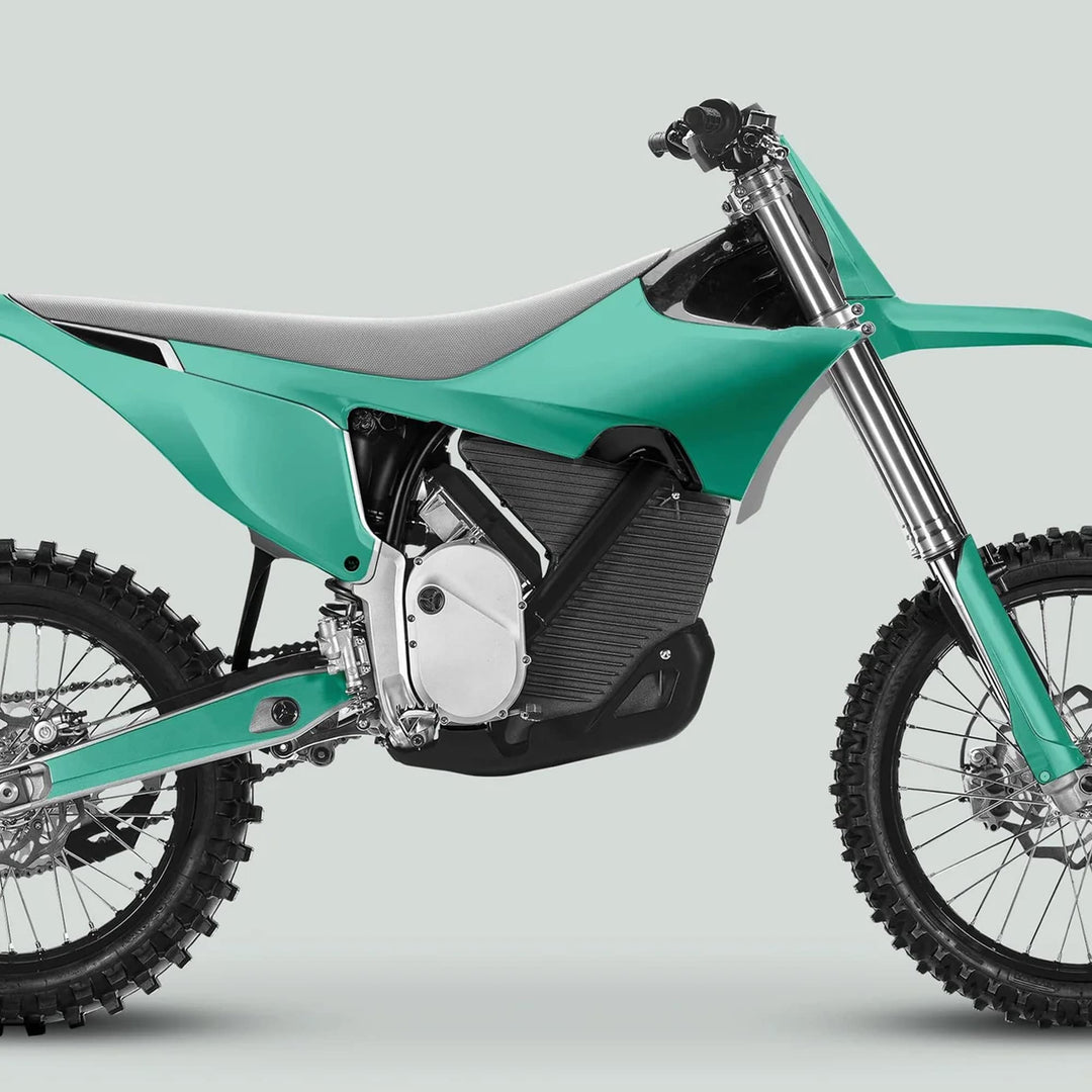 Side profile of an electric dirt motorcycle with Stark Varg Graphics Kit SOLID COLOR MINT Stickers, showcasing knobby tires, front suspension, and glossy decals.