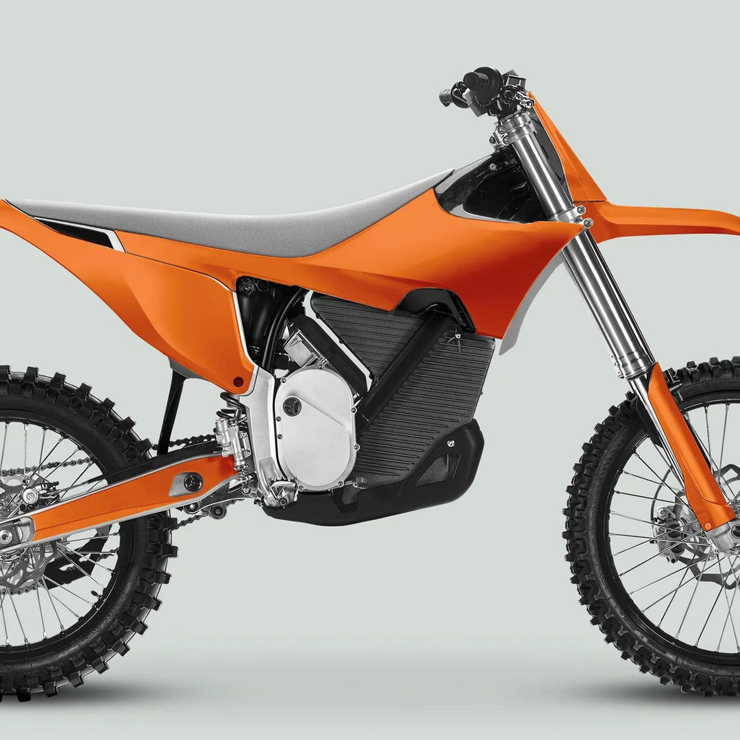 Side-profile of a dirt bike showcasing Stark Varg Graphics Kit SOLID COLOR ORANGE Stickers, featuring vibrant decals for fenders and number plate, enhancing trail-ready design.