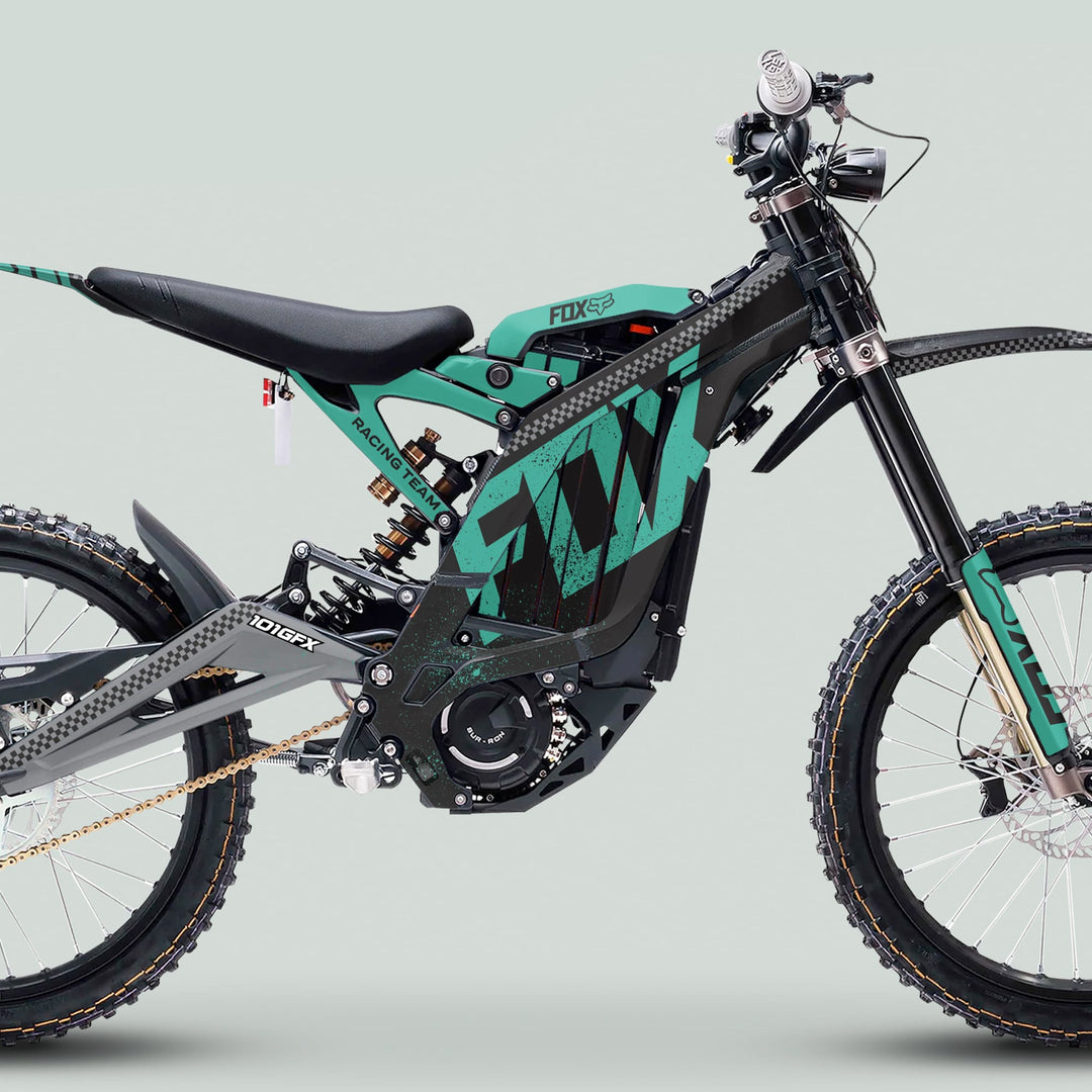 Surron Light Bee X Graphics Kit FOX DUST Black Mint on a teal and black electric dirt bike, featuring high-quality, custom-fit decals for stylish protection.