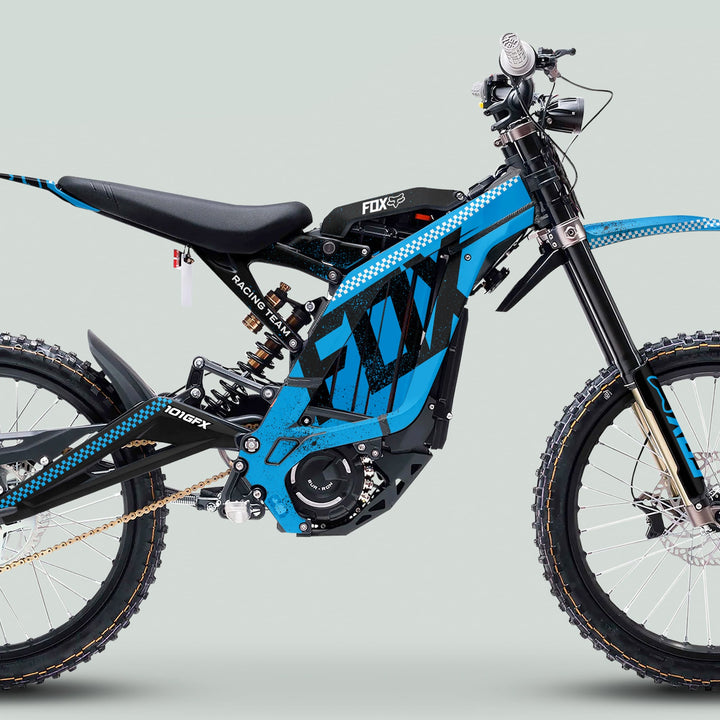 Surron Light Bee X Graphics Kit FOX DUST Cyan Black on an electric off-road motorcycle, featuring knobby tires, FOX suspension, and a sleek racing livery.