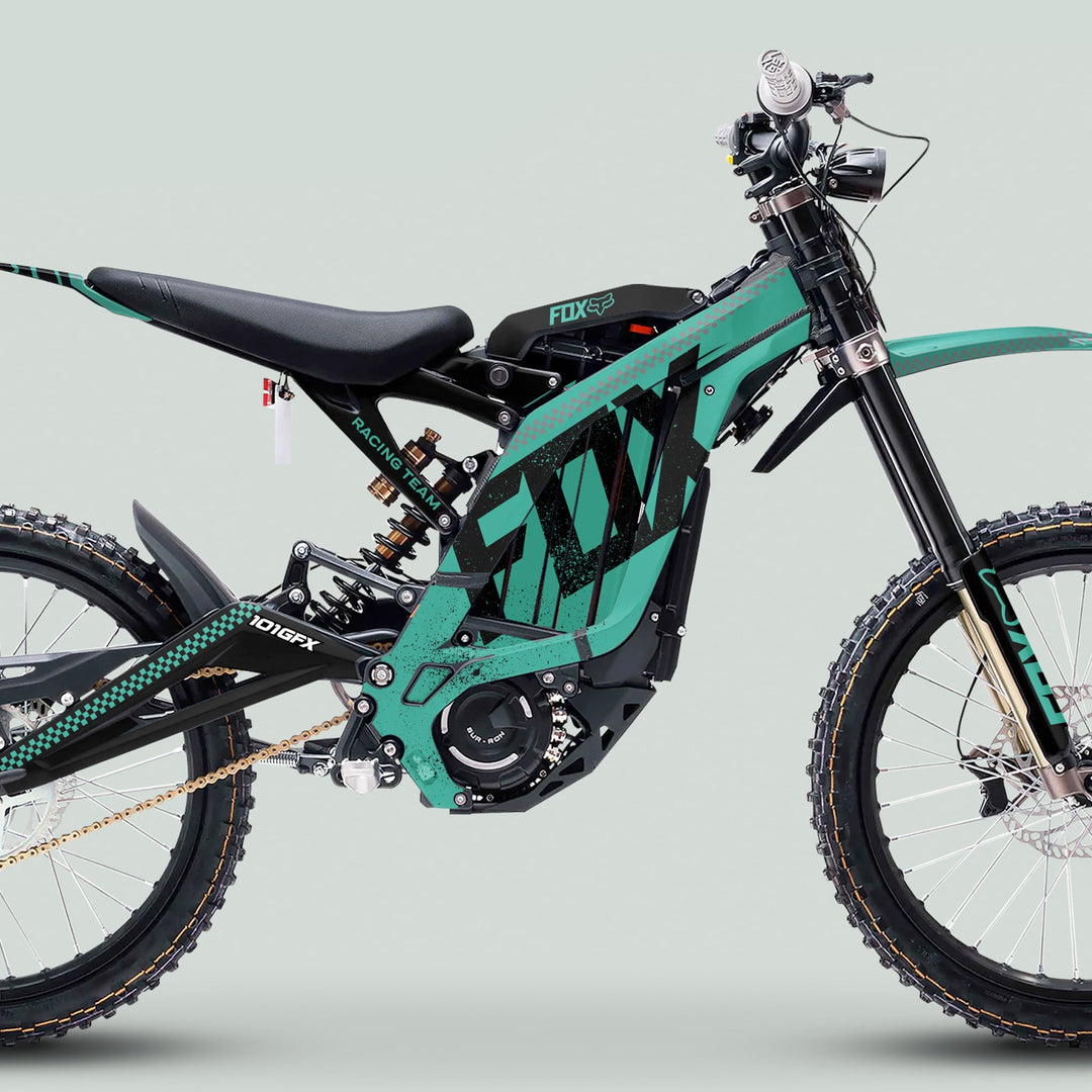 Surron Light Bee X Graphics Kit FOX DUST Mint Black on an electric off-road bike with a downhill frame, knobby tires, and Racing Team graphics.