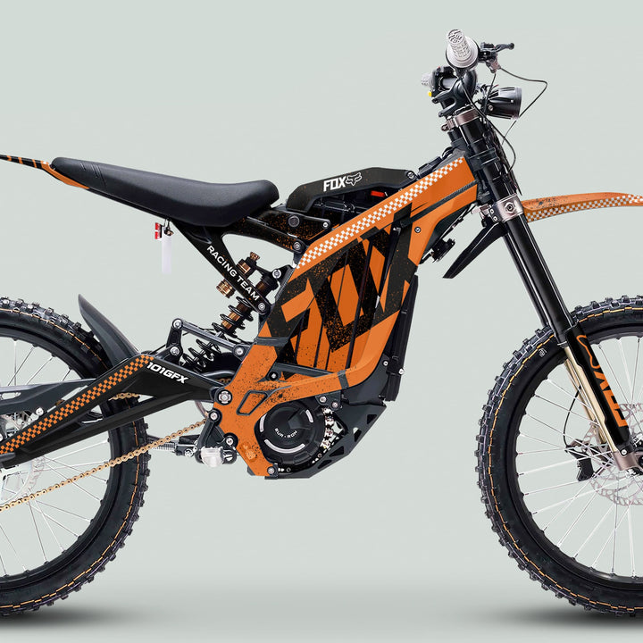 Surron Light Bee X Graphics Kit FOX DUST Orange Black shown on an electric dirt bike, highlighting its black-orange frame, full suspension, and branded decals for trail performance.