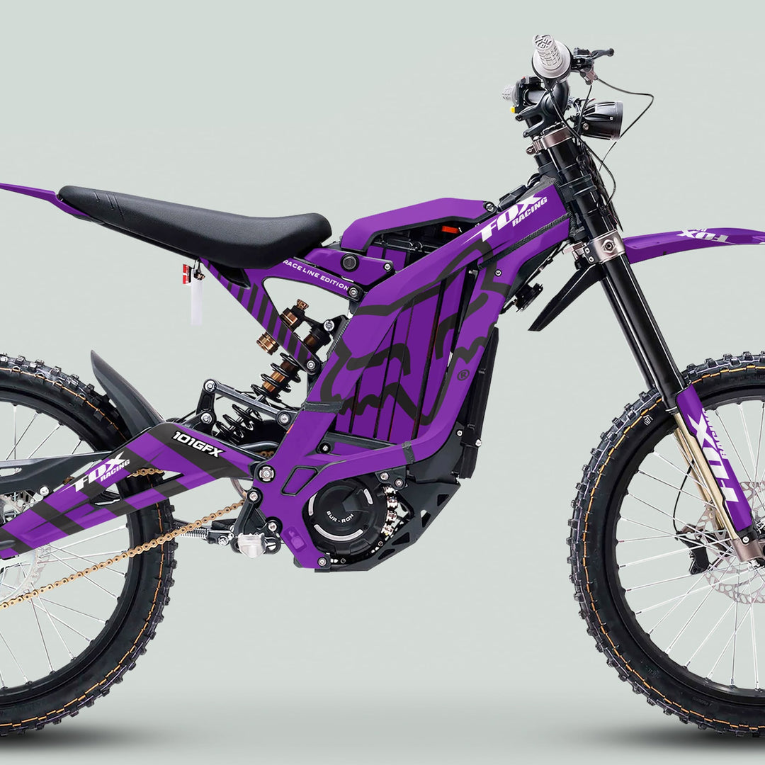 Surron Light Bee X Graphics Kit FOX RACE LINE Purple Black on an electric dirt bike with tubular frame, full suspension, knobby tires, and disc brakes.