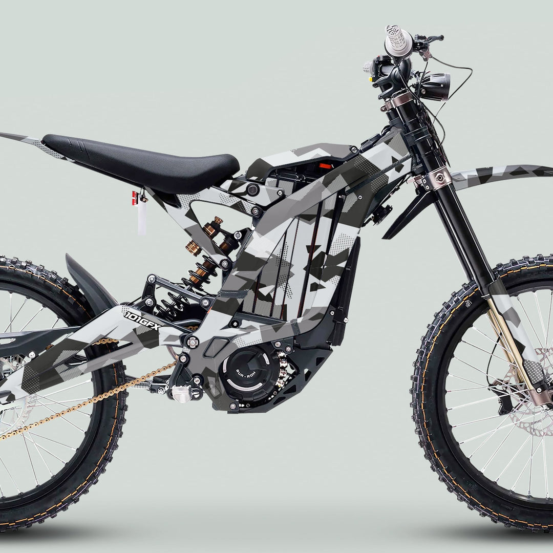 Surron Light Bee X Graphics Kit GEOTECH GREY on an off-road electric dirt bike, highlighting full-suspension frame, knobby tires, and stealthy camouflage wrap for trail riding.