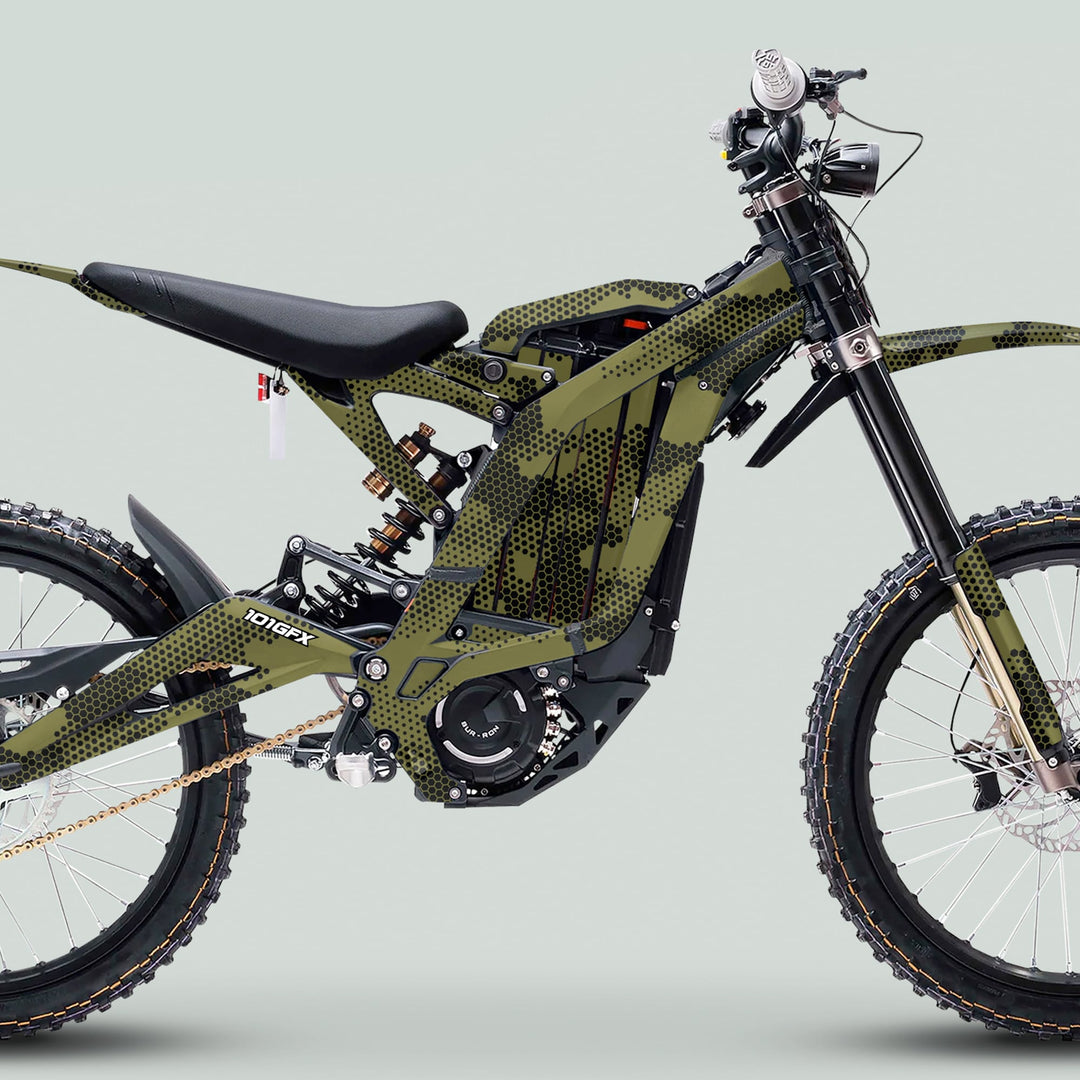 Side-view of an electric dirt bike with Surron Light Bee X Graphics Kit HEXOCAM Olive, featuring a camo pattern, full suspension, and knobby tires.