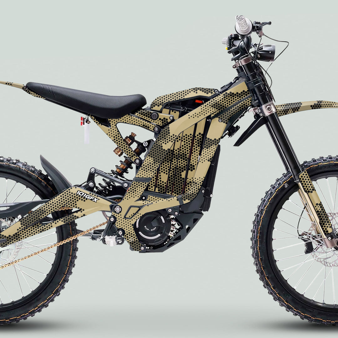 Surron Light Bee X Graphics Kit HEXOCAM Sand on e-dirt bike, featuring knobby tires, full-suspension, chain drive, and camouflage-style wrap for protection and style.