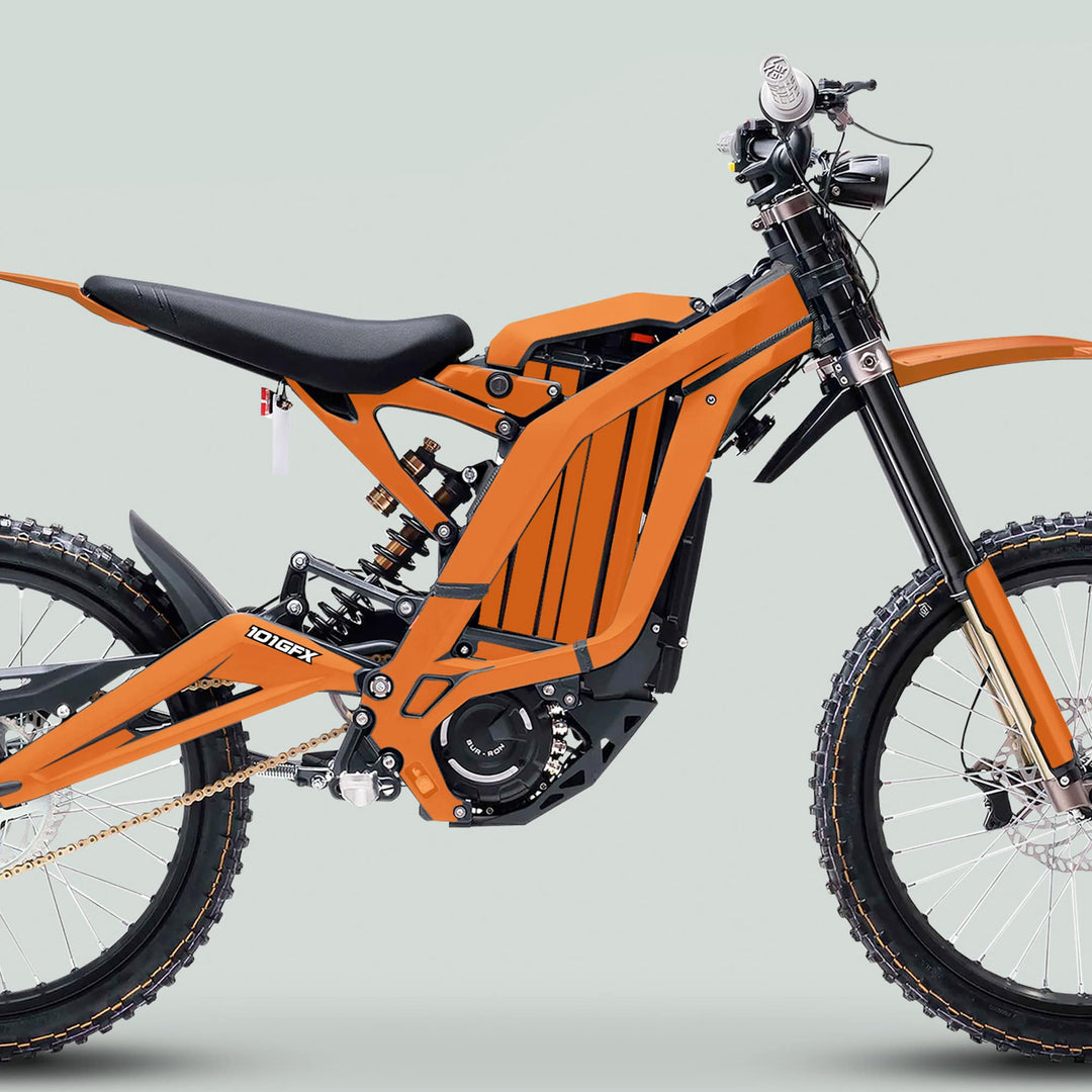 Side-profile of a Surron Light Bee X Graphics Kit MONO COLOR Orange on a dirt bike, highlighting its sleek design, tubular frame, and off-road features.