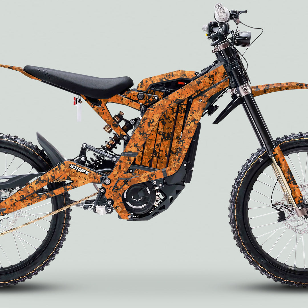 Surron Light Bee X Graphics Kit SQUARE TEK Orange on an e-dirt bike, showcasing camouflaged orange frame and knobby tires for off-road adventures.