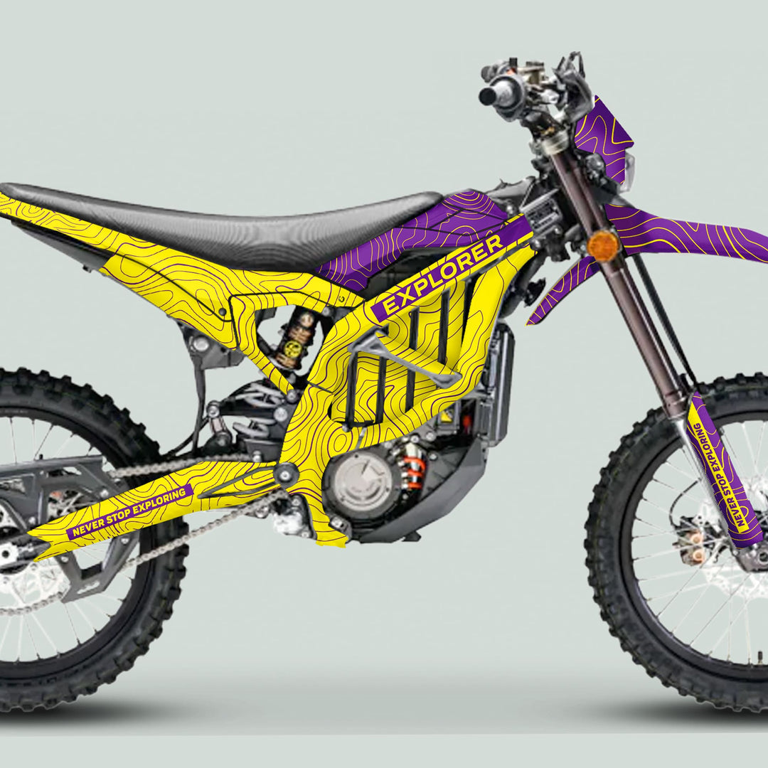 Side view of a Surron Ultra Bee with EXPLORER YELLOW PURPLE graphics kit, featuring contour-line artwork and bold EXPLORER branding.