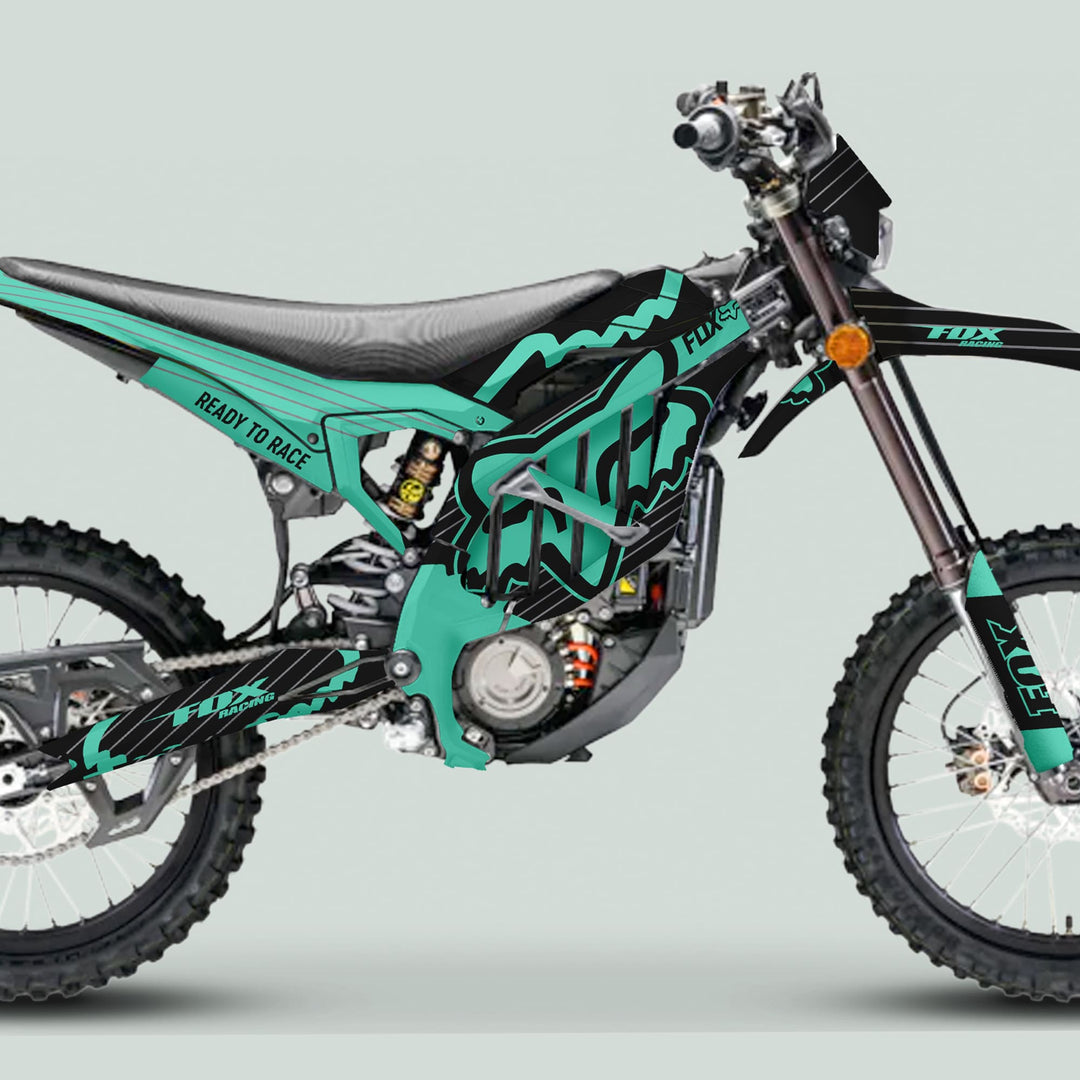 Surron Ultra Bee Graphics Kit FOX STRIPES Black Mint on an off-road bike, showcasing teal and black design with Fox branding, enhancing visual appeal and protection.