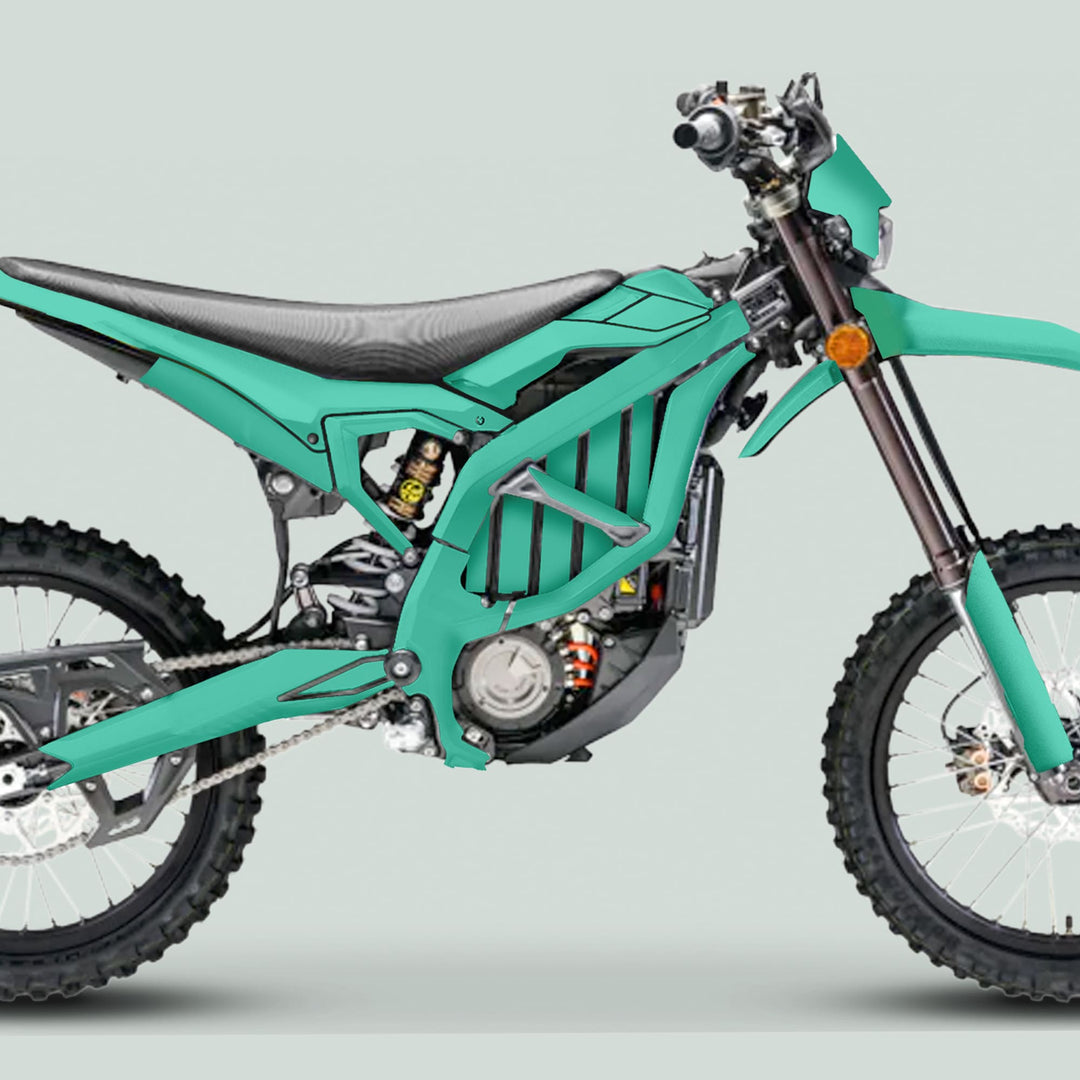 Side view of a Surron Ultra Bee Graphics Kit SOLID COLOR MINT on a dirt bike, highlighting knobby tires and electric motor pack.
