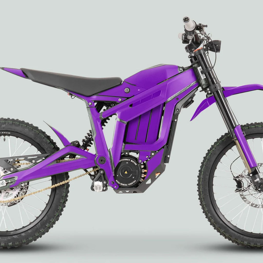 Side-view of a purple Talaria Sting MX3 MX4 Graphics Kit on an electric off-road motorcycle, showcasing its tubular frame, battery compartment, and off-road tires.