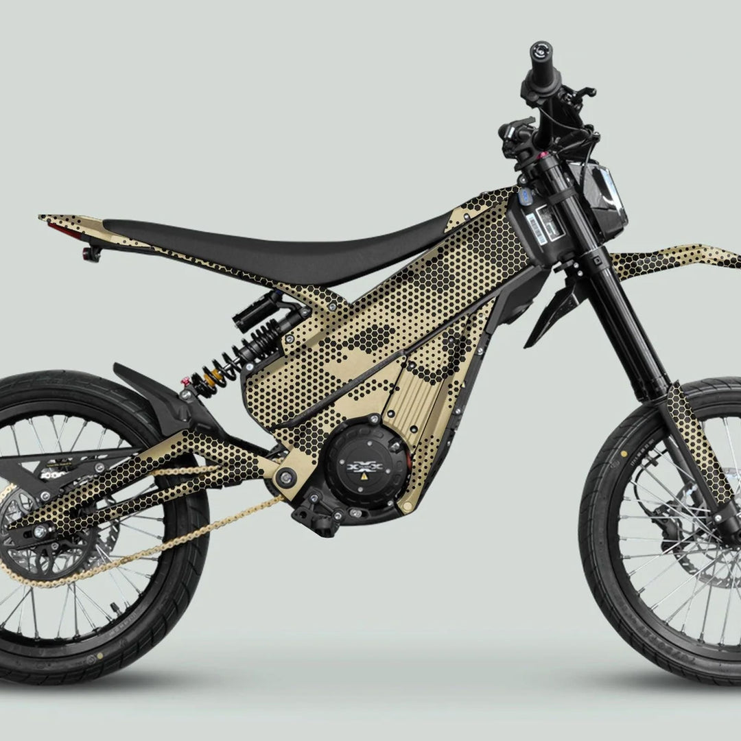 Talaria XXX Graphics Kit HEXOCAM Sande Beige on a sleek electric dirt-bike, showcasing a gold-black honeycomb design, wire-spoke wheels, and off-road suspension.